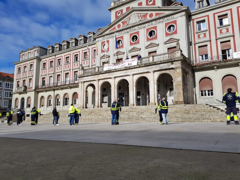 Operarios del naval de Ferrol cuelgan en el cierre de Navantia su ropa de trabajo para visibilizar la falta de trabajo