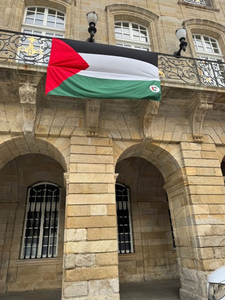 El gobierno local de Santiago coloca en la fachada de Raxoi una bandera palestina para condenar el «genocidio» en Gaza