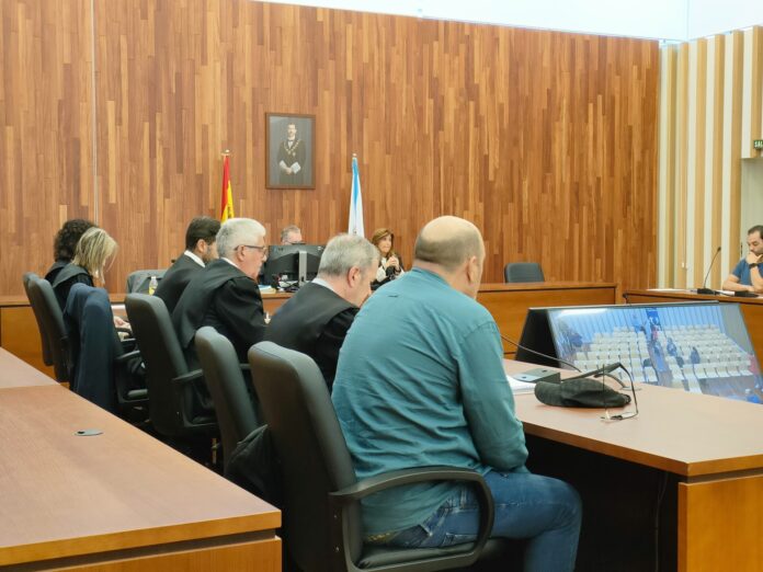 Juicio a José Luis M.C., con camisa verde, acusado por los delitos de asesinato y tenencia ilícita de armas, tras disparar a otro hombre en el barrio vigués de Coia, en abril de 2024.